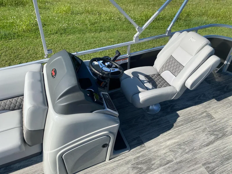 Slide: The Image of 2024 Ranger Reata 223C boat interior with gray seating and steering console. - 6