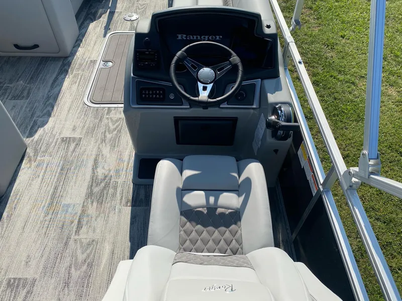 Slide: The Image of 2024 Ranger Reata 223C boat interior with steering wheel and seating. - 7