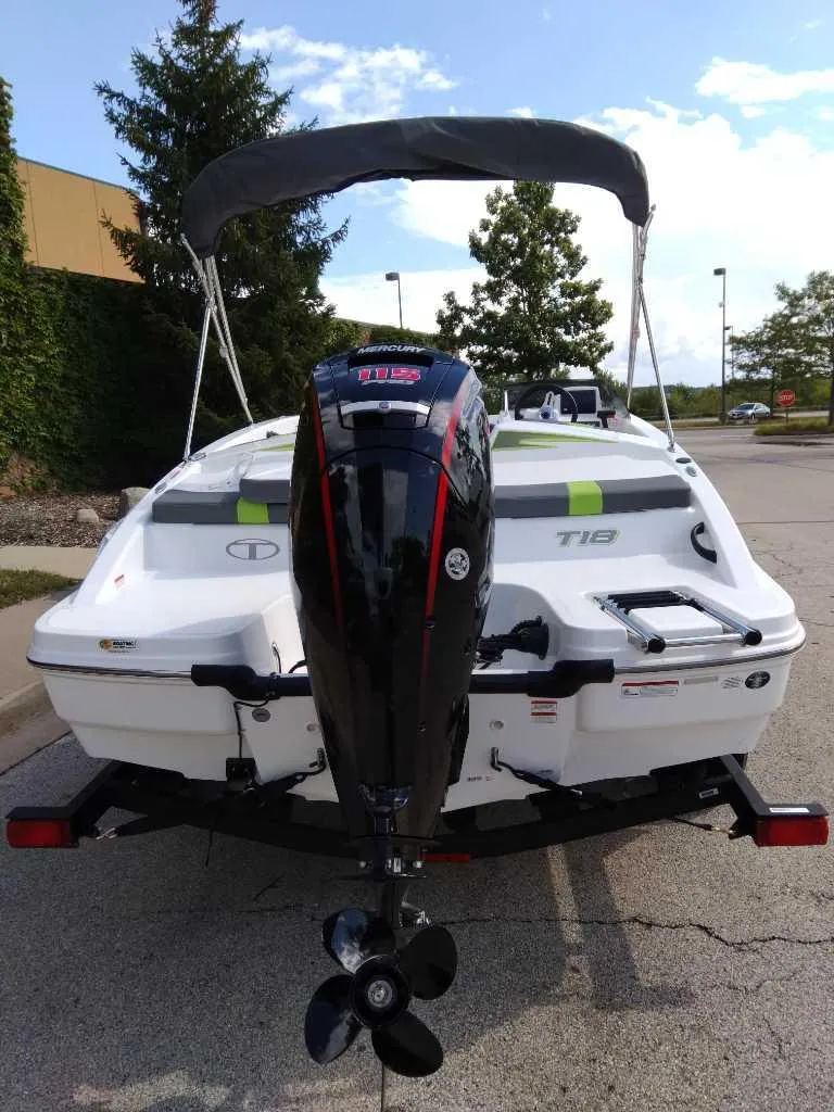 Slide: The Image of 2024 Tahoe T18 boat with outboard motor, parked on a trailer in a sunny area. - 4