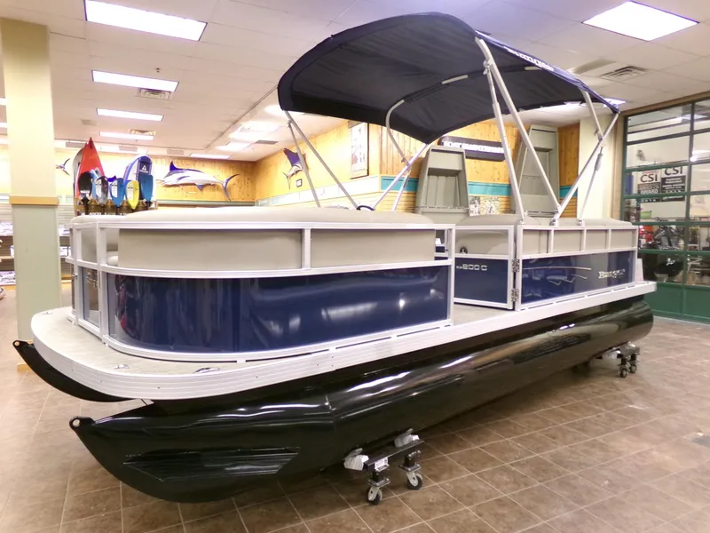 The Image of 2024 Ranger Reata 200C pontoon boat displayed indoors with a blue canopy. - 0