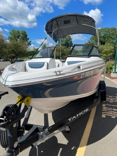 Slide: The Image of 2021 Tahoe TAH500TS boat on trailer, parked outdoors under blue sky. - 4