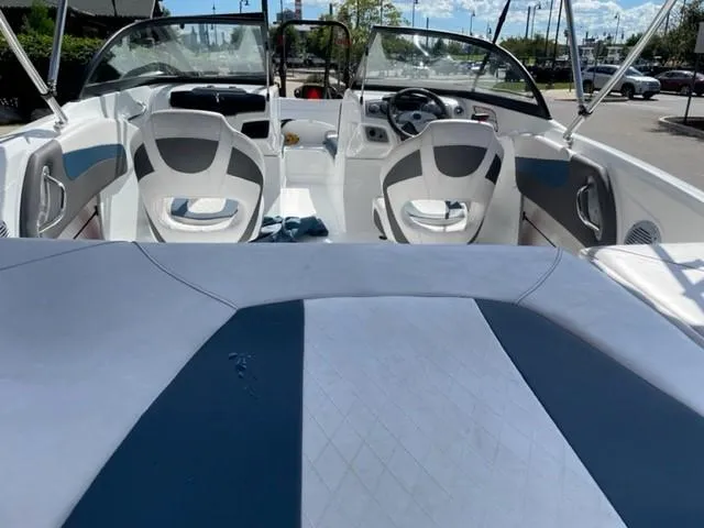 Slide: The Image of 2021 Tahoe TAH500TS boat interior with white and blue seating, dashboard, and steering wheel. - 6