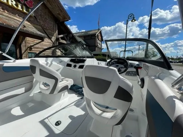 Slide: The Image of 2021 Tahoe TAH500TS boat interior with white seating and dashboard, under a blue sky. - 9