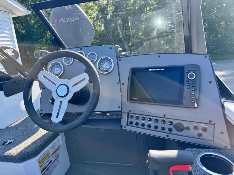 Slide: The Image of 2025 Vexus ADX180LS boat dashboard with steering wheel and navigation system. - 5