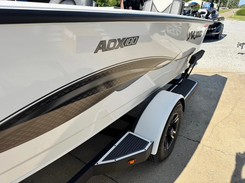 Slide: The Image of 2025 Vexus ADX180LS boat on trailer, side view, white with black accents. - 9