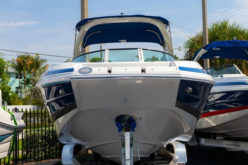 Slide: The Image of 2022 Crownline E 255 XS boat displayed outdoors, front view. - 1