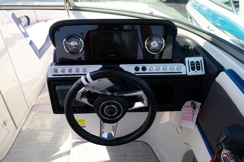 Slide: The Image of 2022 Crownline E 255 XS boat dashboard with steering wheel and control panel. - 11