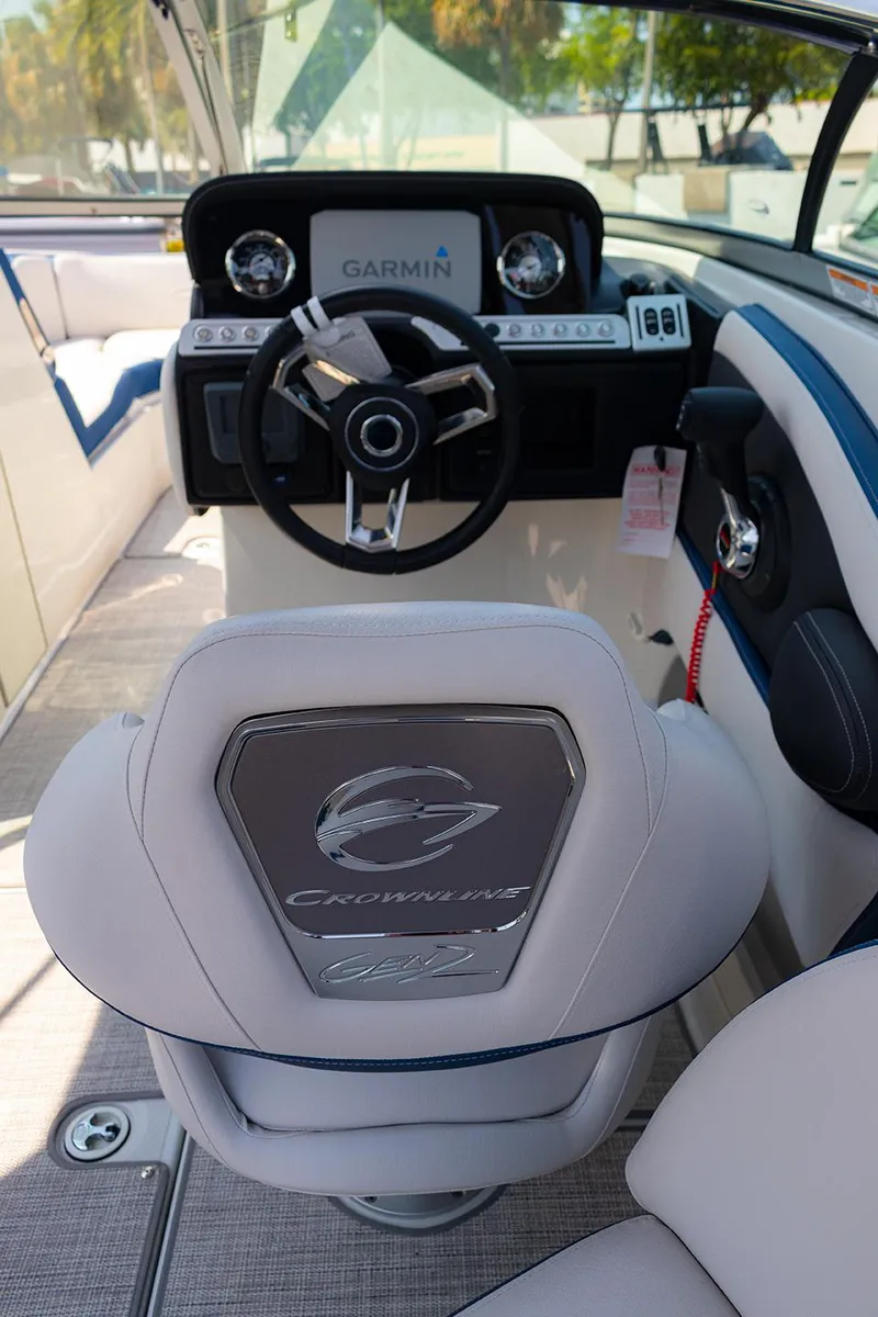 Slide: The Image of 2022 Crownline E 255 XS boat interior with Garmin navigation system and steering wheel. - 12