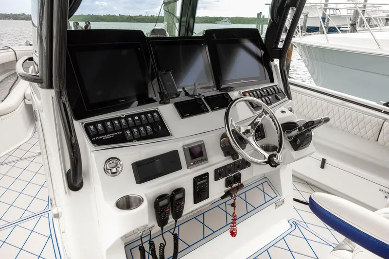 Slide: The Image of 2014 Hydra-Sports 42 Custom Siesta boat cockpit with advanced navigation controls and steering wheel. - 19