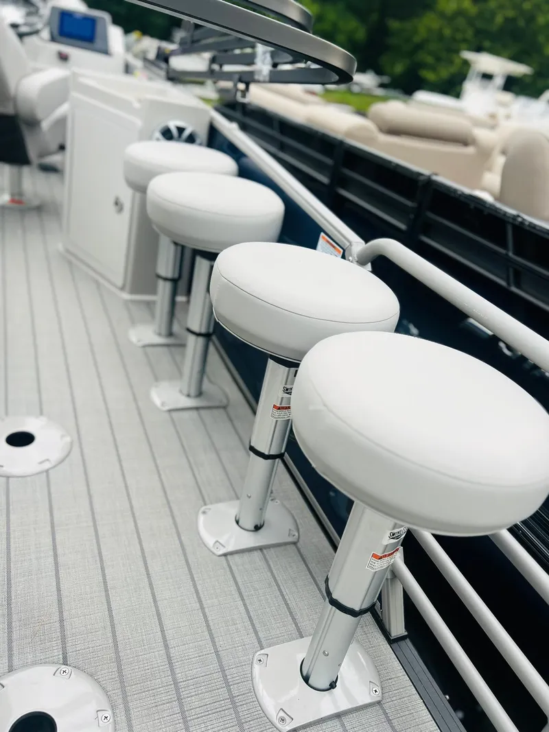 Slide: The Image of 2025 Starcraft CX 23 DL BAR boat with white bar stools on deck. - 13