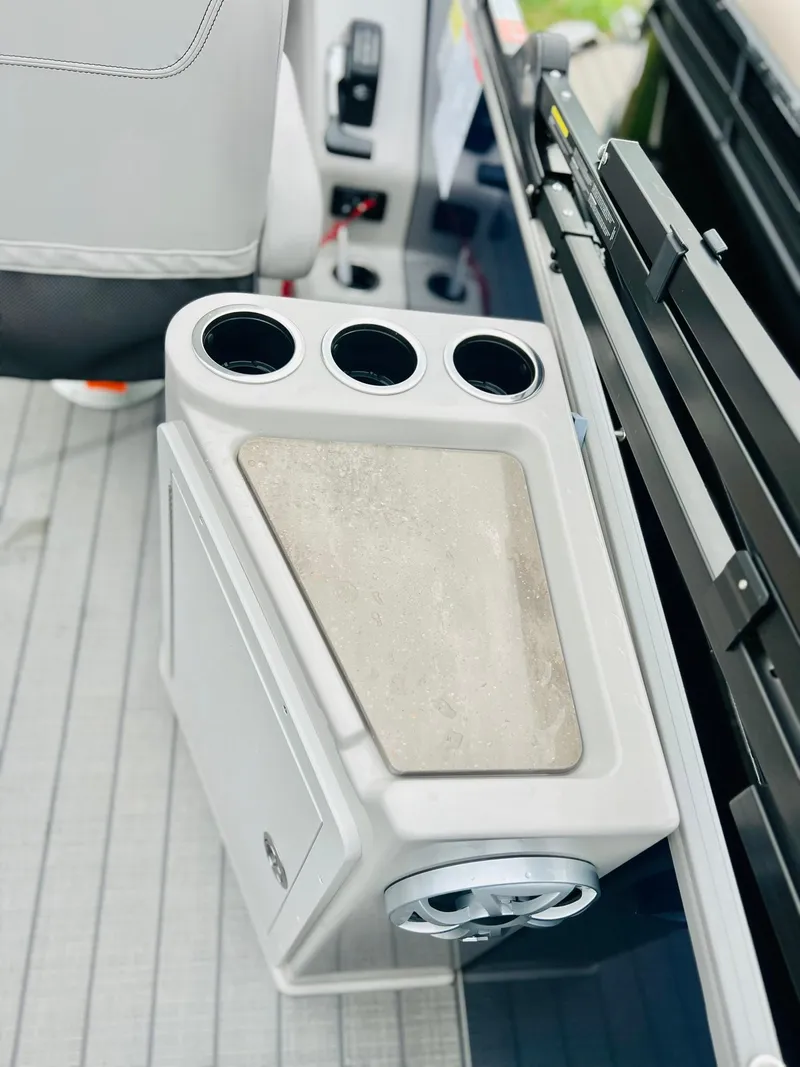 Slide: The Image of 2025 Starcraft CX 23 DL BAR boat interior with cup holders and storage compartment. - 2