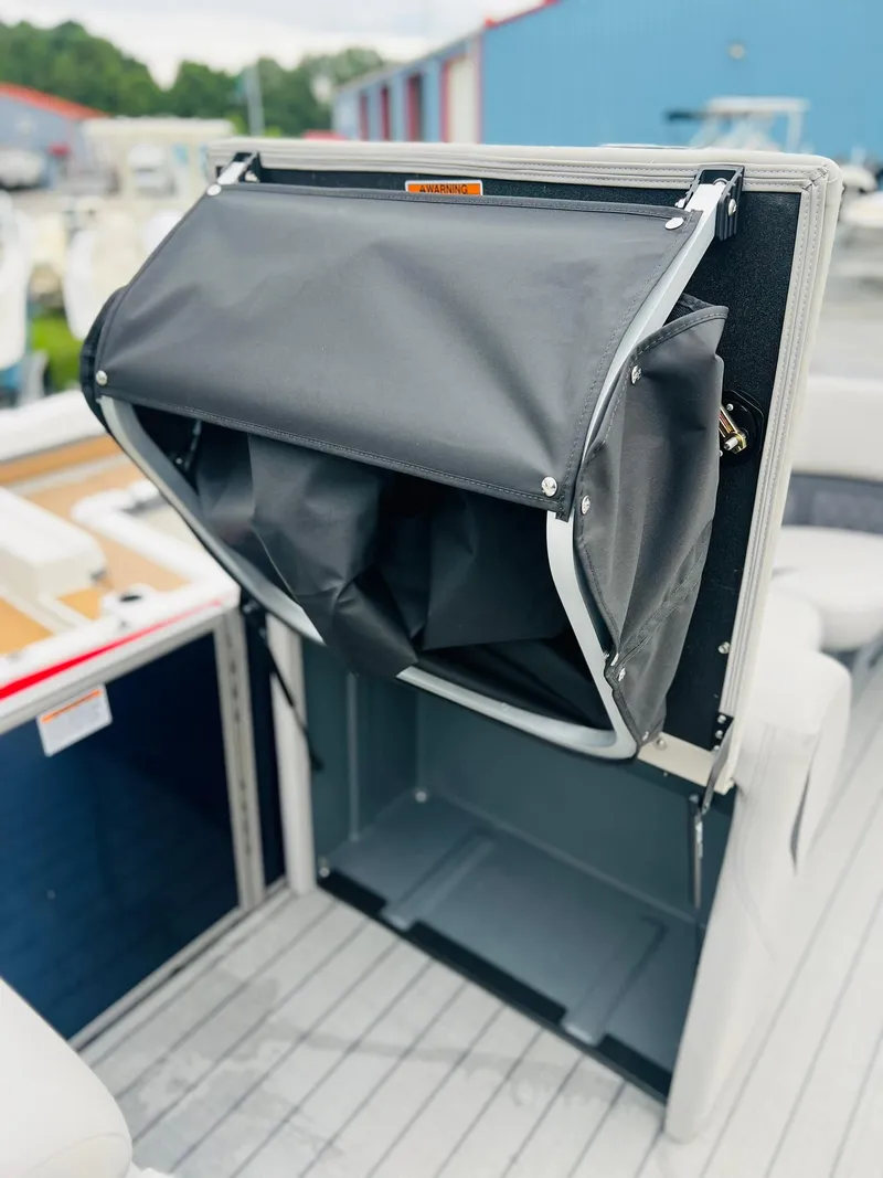 Slide: The Image of 2025 Starcraft CX 23 DL BAR boat interior with storage compartment open. - 3