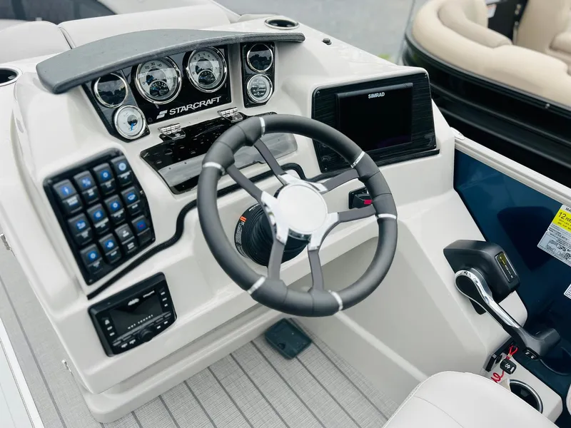 Slide: The Image of 2025 Starcraft CX 23 DL BAR boat dashboard with steering wheel and control panel. - 8