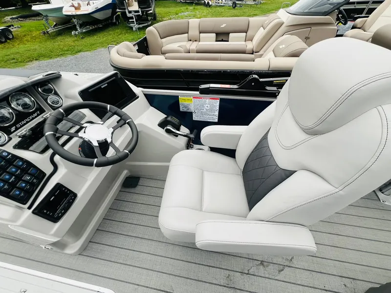 Slide: The Image of 2025 Starcraft CX 23 DL BAR boat interior with steering wheel and plush seating. - 9