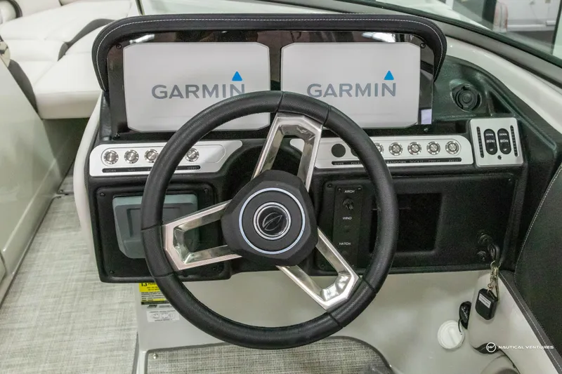 Slide: The Image of Steering wheel and Garmin displays on 2023 Crownline 260 XSS boat dashboard. - 19