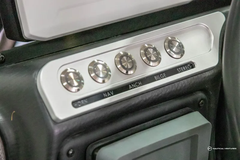 Slide: The Image of 2023 Crownline 260 XSS control panel with navigation, anchor, bilge, and stereo switches. - 21
