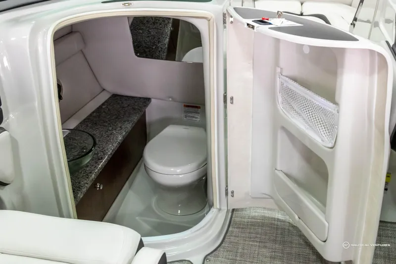 Slide: The Image of 2023 Crownline 260 XSS boat interior with compact bathroom and modern amenities. - 26