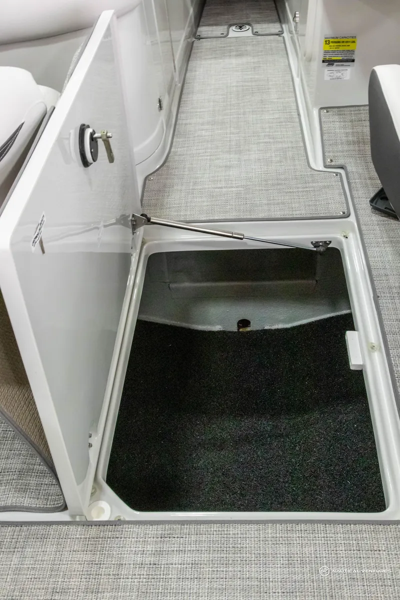 Slide: The Image of 2023 Crownline 260 XSS boat interior storage compartment with open hatch. - 32
