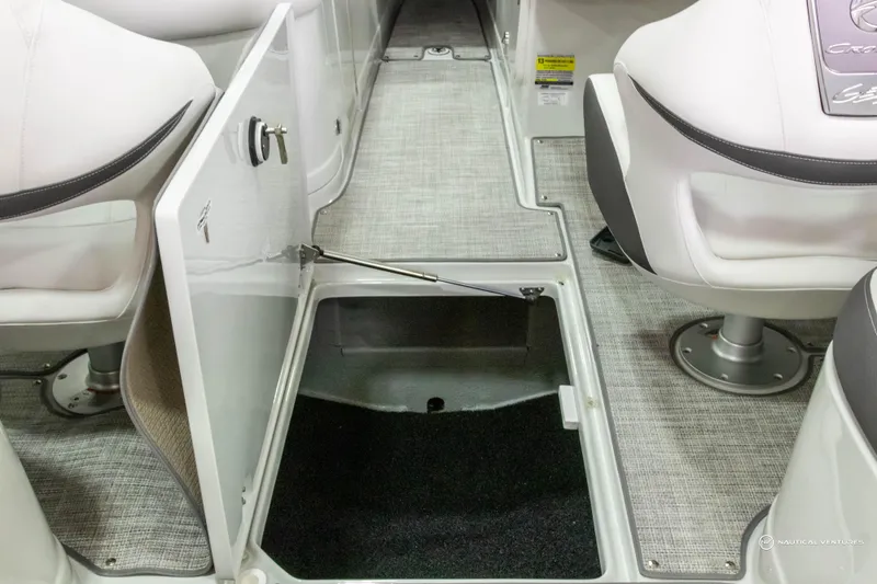Slide: The Image of 2023 Crownline 260 XSS boat interior with open storage compartment and seating. - 33