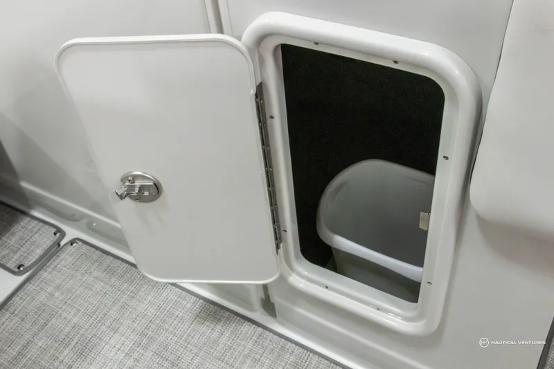 Slide: The Image of 2023 Crownline 260 XSS boat storage compartment with open door and visible interior. - 37