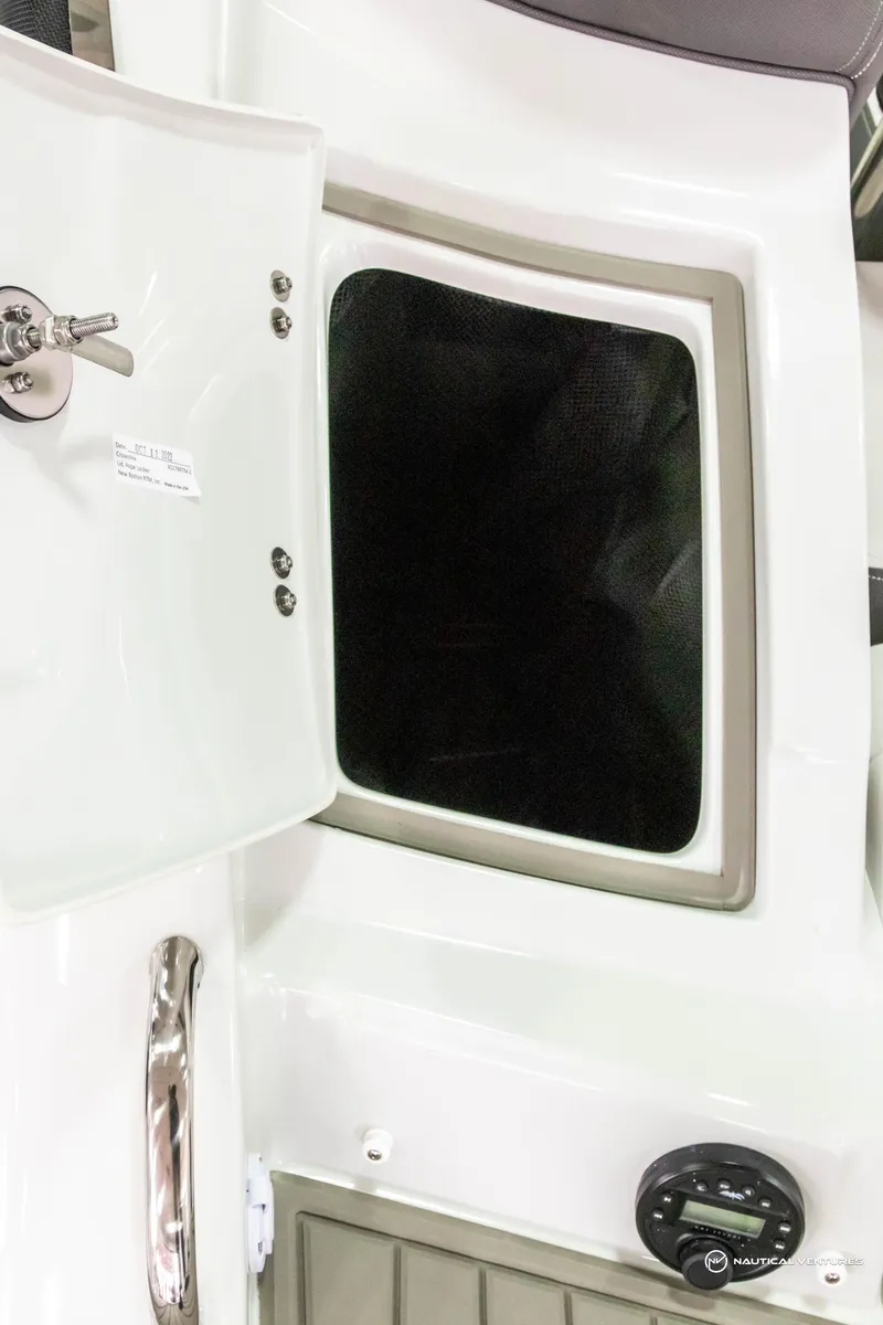 Slide: The Image of 2023 Crownline 260 XSS boat interior storage compartment and control panel. - 38