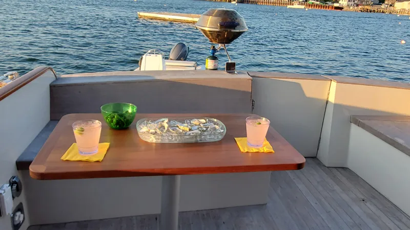 Slide: The Image of 1997 Lyman-Morse Custom Flybridge yacht with drinks and snacks on deck, overlooking the ocean. - 10