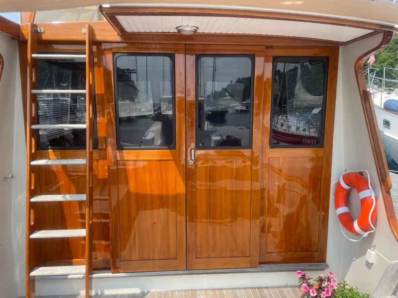 Slide: The Image of 1997 Lyman-Morse Custom Flybridge with polished wood doors and ladder, featuring a life preserver. - 13