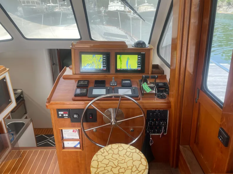 Slide: The Image of 1997 Lyman-Morse Custom Flybridge helm with navigation screens and wooden interior. - 15