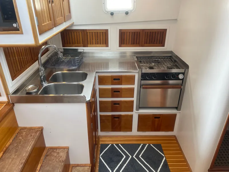 Slide: The Image of 1997 Lyman-Morse Custom Flybridge kitchen with stainless steel sink, stove, and wooden cabinetry. - 18