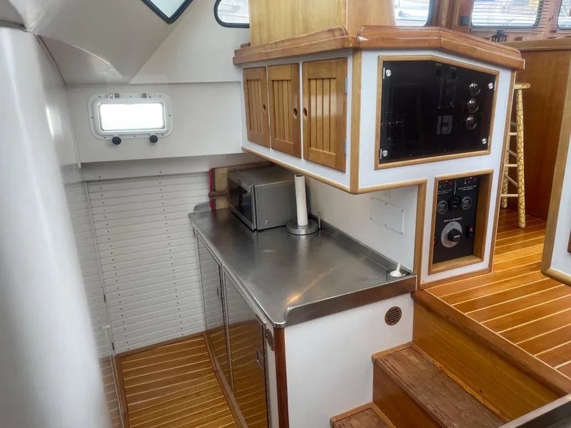 Slide: The Image of 1997 Lyman-Morse Custom Flybridge interior with wooden cabinetry and stainless steel countertop. - 19