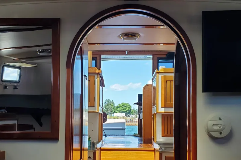 Slide: The Image of Interior view of 1997 Lyman-Morse Custom Flybridge yacht with wooden finishes and open door. - 23
