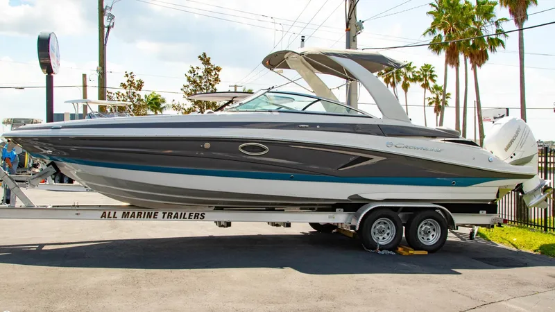 Slide: The Image of 2023 Crownline 290 XSS boat on trailer, parked outdoors. - 3
