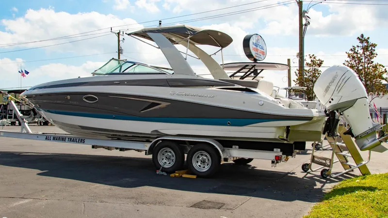 Slide: The Image of 2023 Crownline 290 XSS boat on trailer, parked outdoors. - 4