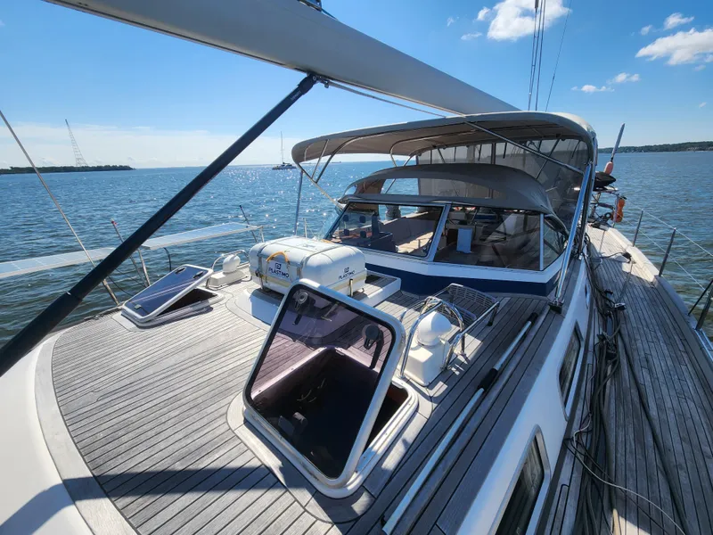 Slide: The Image of 2008 Hallberg-Rassy 62 yacht on calm waters, featuring spacious deck and sleek design. - 14