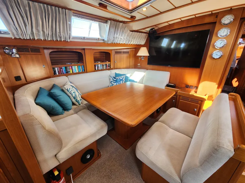 Slide: The Image of Luxurious 2008 Hallberg-Rassy 62 yacht interior with cozy seating and elegant wooden table. - 27