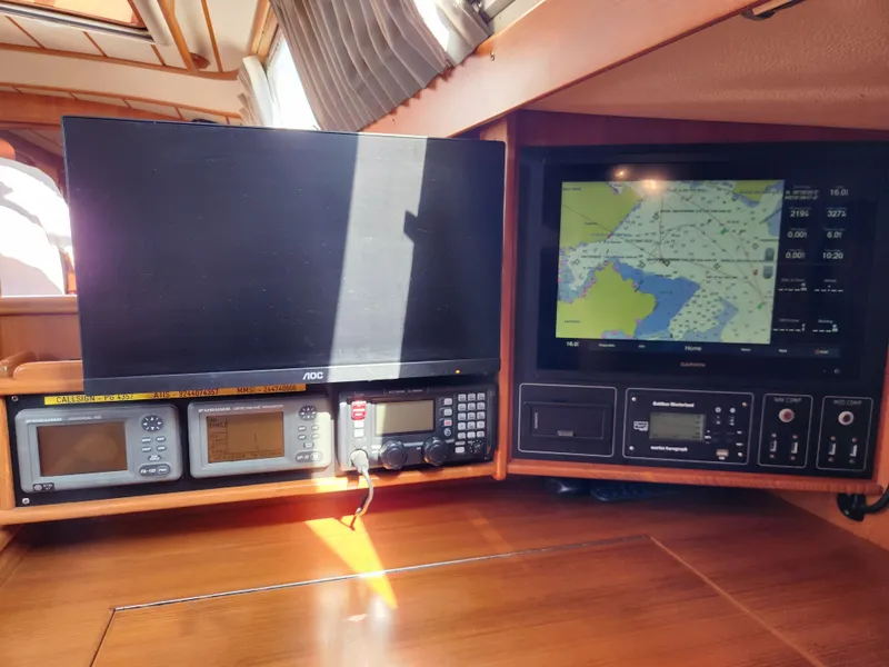 Slide: The Image of Navigation equipment on a 2008 Hallberg-Rassy 62 yacht, featuring screens and control panels. - 34
