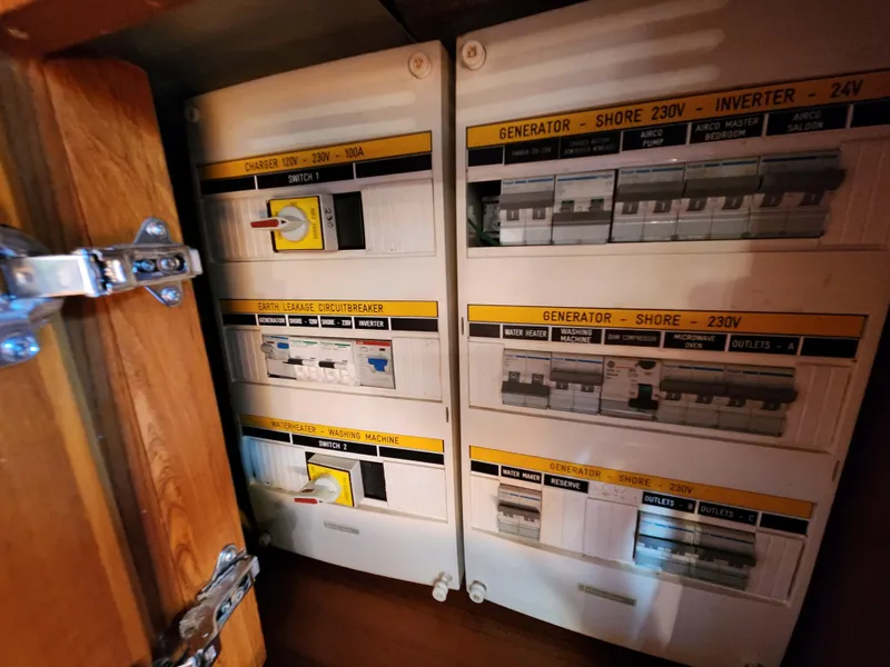 Slide: The Image of Electrical panel on a 2008 Hallberg-Rassy 62 yacht, featuring various switches and circuit breakers. - 35