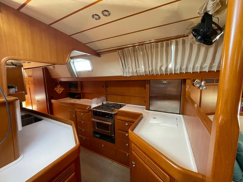 Slide: The Image of Interior of 2008 Hallberg-Rassy 62 yacht kitchen with wooden cabinetry and modern appliances. - 36
