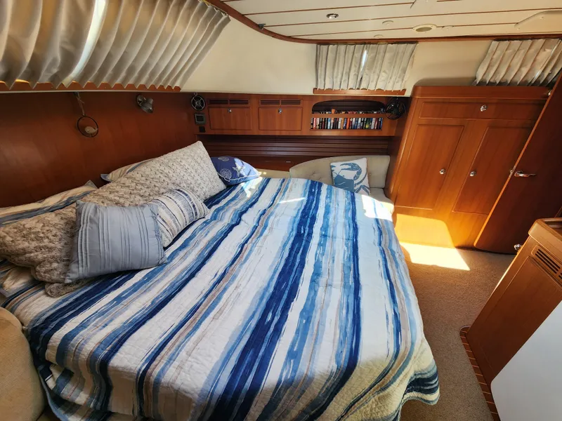 Slide: The Image of Luxurious cabin interior of 2008 Hallberg-Rassy 62 yacht with striped bedding and wooden furnishings. - 41
