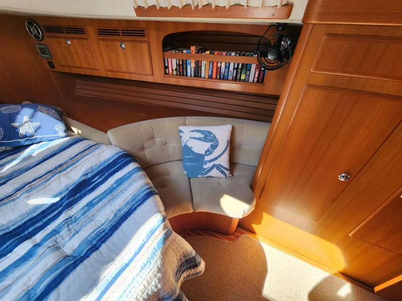 Slide: The Image of Cozy cabin interior of 2008 Hallberg-Rassy 62 yacht with bed, books, and seating area. - 42