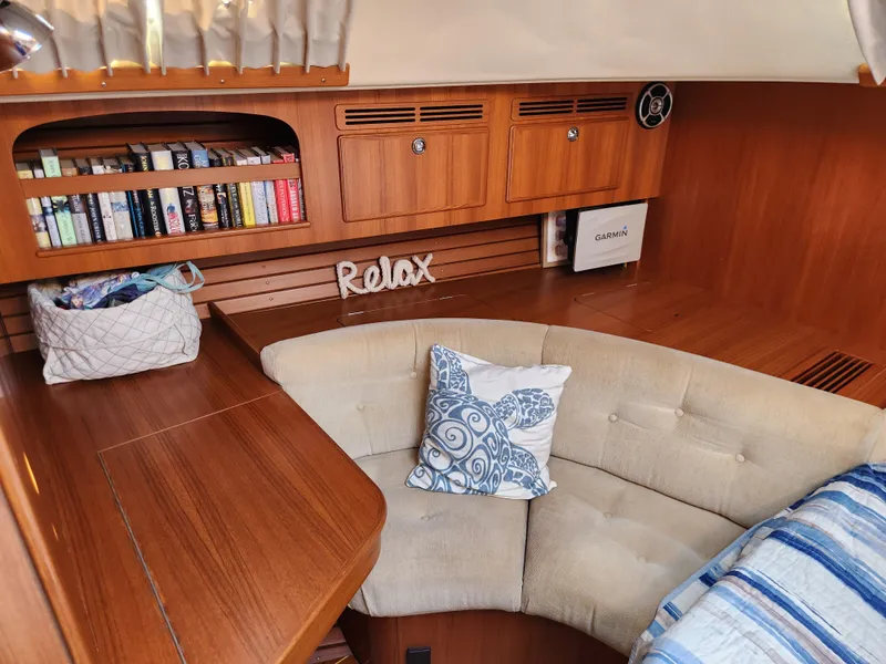 Slide: The Image of Cozy interior of 2008 Hallberg-Rassy 62 yacht with books, cushions, and wooden finish. - 45
