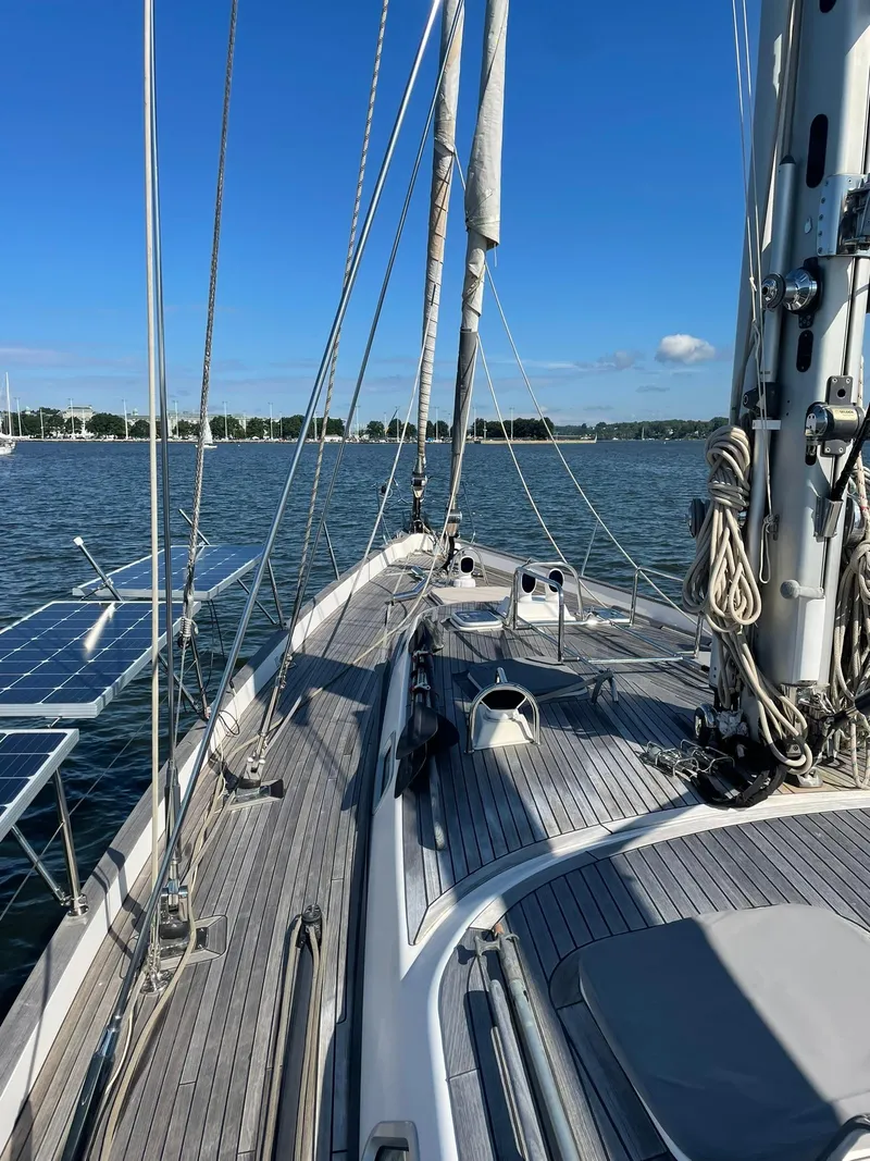Slide: The Image of 2008 Hallberg-Rassy 62 sailboat deck with clear blue sky and calm waters. - 8