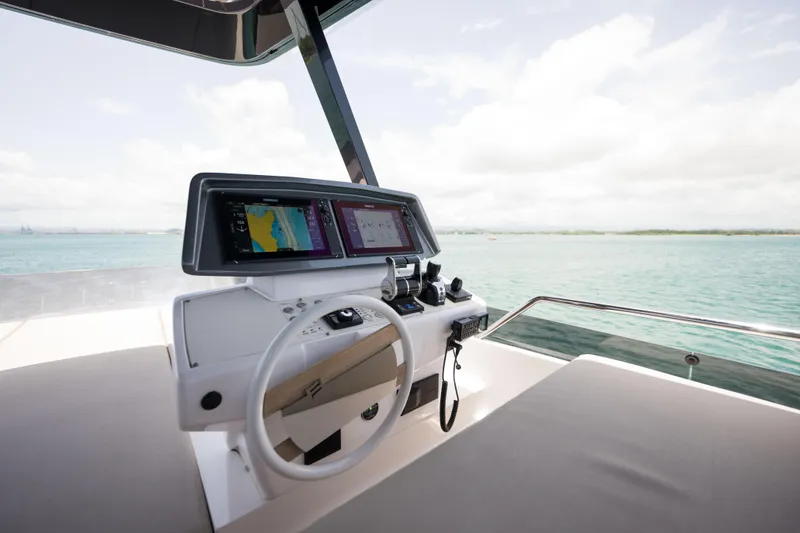 Slide: The Image of Modern helm of 2023 Ferretti Yachts 720 with dual navigation screens, overlooking serene waters. - 17