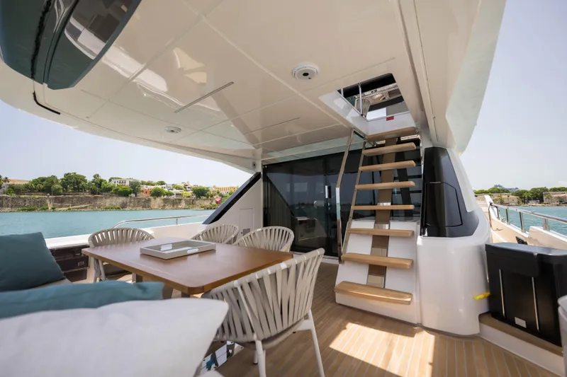 Slide: The Image of Luxurious 2023 Ferretti Yachts 720 deck with seating and staircase, overlooking serene waters. - 28