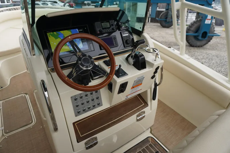 Slide: The Image of 2018 Chris-Craft Catalina 26 helm with steering wheel, navigation controls, and display screens. - 12