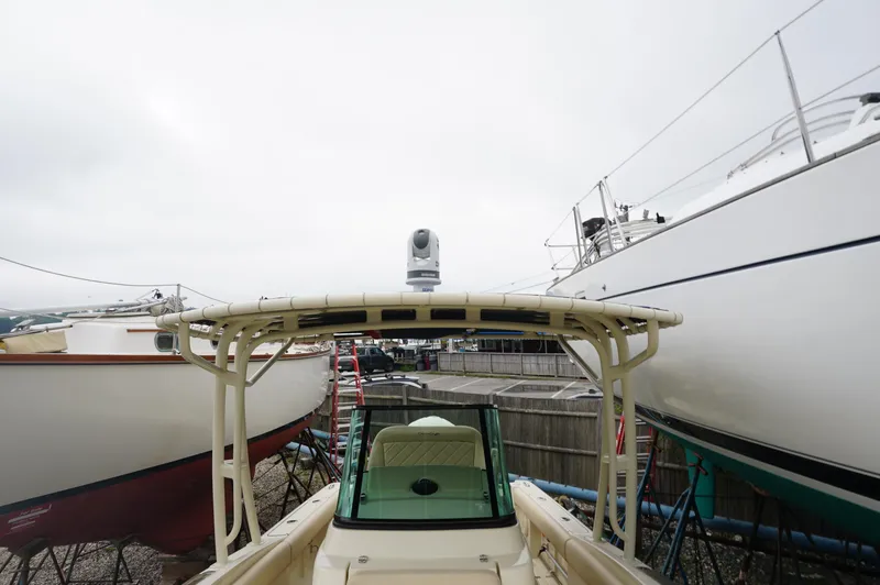 Slide: The Image of 2018 Chris-Craft Catalina 26 boat docked between other vessels on a cloudy day. - 9