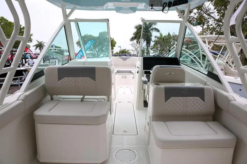 Slide: The Image of 2025 Sailfish 276 DC boat interior with cushioned seating and modern dashboard. - 4