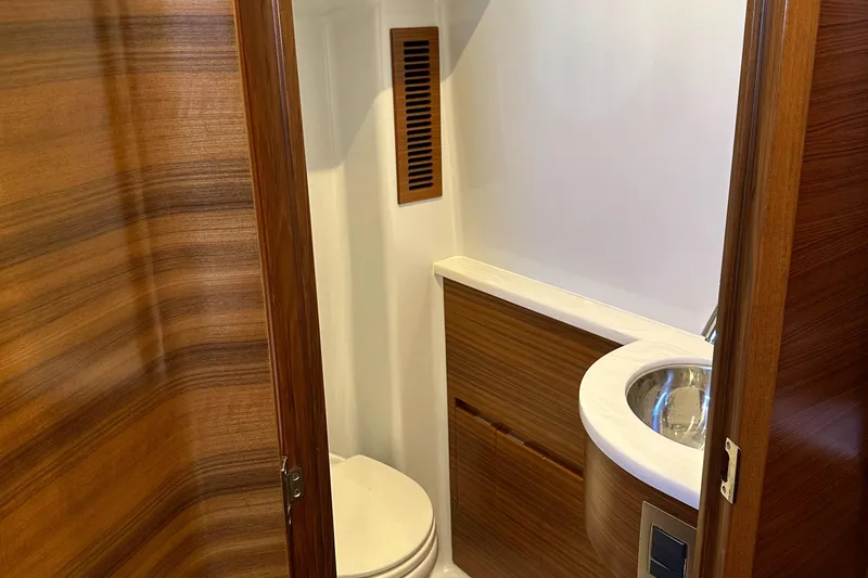 Slide: The Image of 2022 Weaver Center Console boat bathroom with wooden accents and modern fixtures. - 14