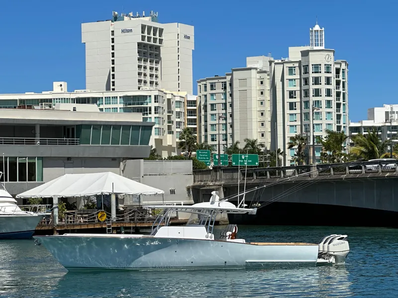 Slide: The Image of 2022 Weaver Center Console boat on water with city buildings in the background. - 2