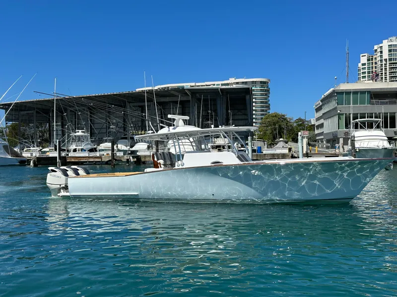Slide: The Image of 2022 Weaver Center Console boat docked in a marina with modern buildings. - 3